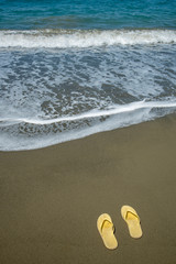 Yellow sandals on a golden sandy beach