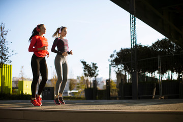 Scenery of two female joggers pursuing their activity outdoors in the city