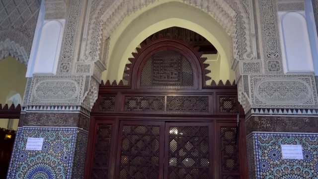 The entrance door of oak, with bronze hardware, surmounted by tracery in eucalyptus wood