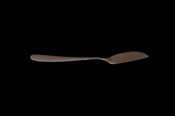 fork plate and knife isolated against black background
