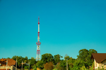 TV tower local infrastructure object in small colorful European city wallpaper poster picture and bright blue sky background with empty copy space for text