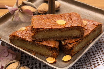 Fresh baked Dutch filled spicy cookies with almonds in autumn colors on dark wooden background