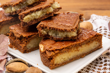 Fresh baked Dutch filled spicy cookies with almonds in autumn colors on dark wooden background