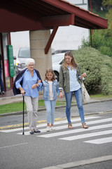 Grandmother, mother and daughter crossing the street