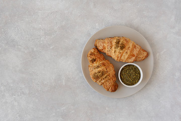 Fresh croissants with zaatar on light stone background. Top view