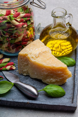 Cheese collection, piece of hard aged Italian parmesan or grana padano cheese with olive oil and tricolore italian pasta