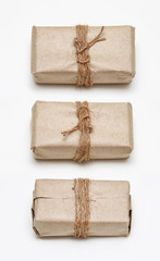 Set of different sides of the same parcel wrapping in brown craft paper and tie hemp string. Package. Delivery service. Online shopping. Your purchase. Gift box on a table. Isolation on white.