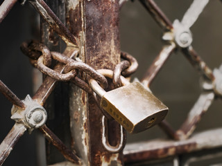 Closeup of padlock locking old iron entrance concept of forbidden