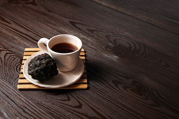 Saucer and Cup, Tamarind tea (or Date Tea), dry ball from the seeds and resins of Indian tamarind on a brown table. Exotic drink on a natural wooden background