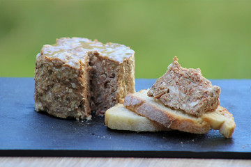 Pâté de campagne du terroir avec tartine de pâté sur fond ardoise