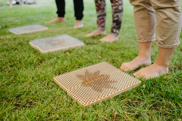 Legs of a girl standing on a Board with sharp nails. Close up. Extreme yoga