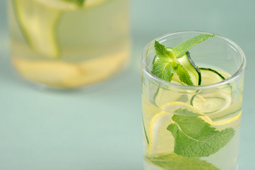 Refreshing cold water with lemon, cucumber, mint and ice. A cleansing drink for the body of sassi. Close-up.