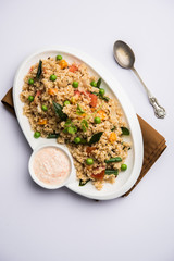 Broken wheat or Daliya Upma, served in a bowl. selective focus
