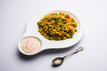 Broken wheat or Daliya Upma, served in a bowl. selective focus