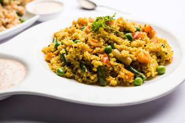 Broken wheat or Daliya Upma, served in a bowl. selective focus