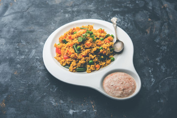Broken wheat or Daliya Upma, served in a bowl. selective focus