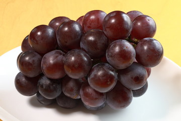 Black grapes on white background