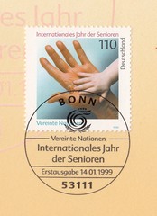 Child's hand in the palm of an grownup.International year of older persons.Postmark Bonn,stamp Germany 1999