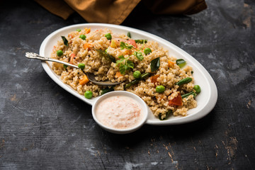 Broken wheat or Daliya Upma, served in a bowl. selective focus