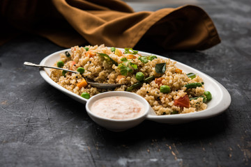 Broken wheat or Daliya Upma, served in a bowl. selective focus