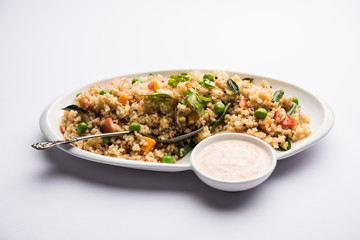 Broken wheat or Daliya Upma, served in a bowl. selective focus