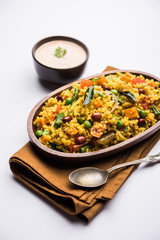 Broken wheat or Daliya Upma, served in a bowl. selective focus