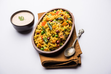 Broken wheat or Daliya Upma, served in a bowl. selective focus