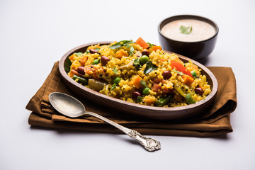 Broken wheat or Daliya Upma, served in a bowl. selective focus