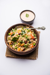 Broken wheat or Daliya Upma, served in a bowl. selective focus