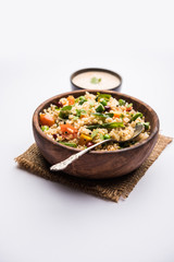 Broken wheat or Daliya Upma, served in a bowl. selective focus