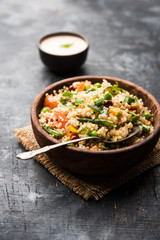 Broken wheat or Daliya Upma, served in a bowl. selective focus