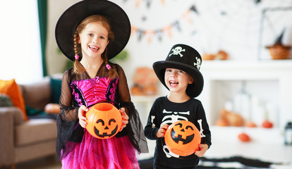 . happy Halloween! two children in suits and with pumpkins in home.