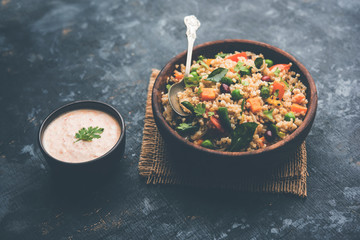 Broken wheat or Daliya Upma, served in a bowl. selective focus