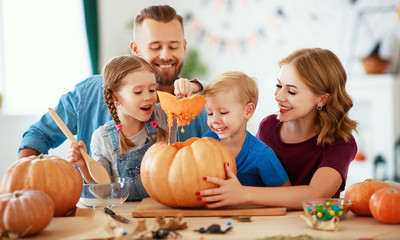 Fototapeta premium happy Halloween! family mother father and children cut pumpkin for holiday at home..