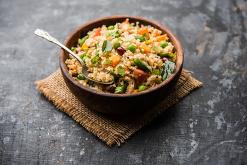 Broken wheat or Daliya Upma, served in a bowl. selective focus