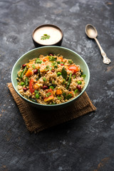 Broken wheat or Daliya Upma, served in a bowl. selective focus