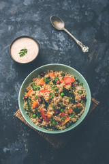 Broken wheat or Daliya Upma, served in a bowl. selective focus