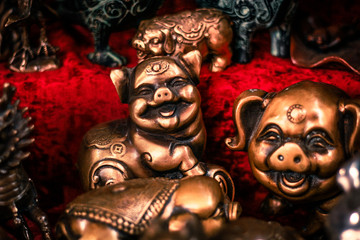 Buddhist figurines and masks of mythological characters in gold and bronze on a burgundy with a red background