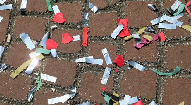 colorful confetti scattered on the ground after a carnival parad