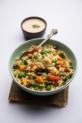Broken wheat or Daliya Upma, served in a bowl. selective focus