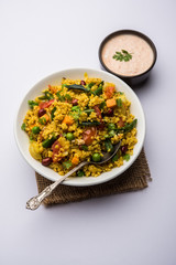Broken wheat or Daliya Upma, served in a bowl. selective focus