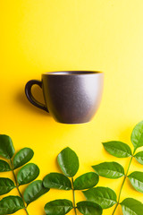 Flat lay of cup on yellow background with copy space