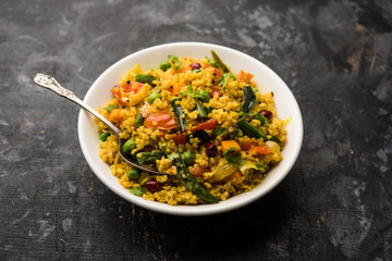 Broken wheat or Daliya Upma, served in a bowl. selective focus