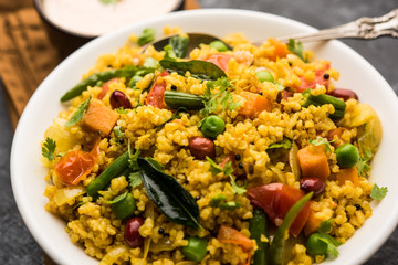 Broken wheat or Daliya Upma, served in a bowl. selective focus