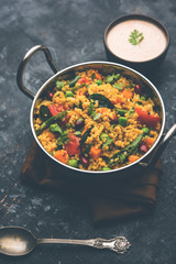Broken wheat or Daliya Upma, served in a bowl. selective focus