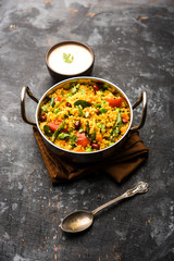 Broken wheat or Daliya Upma, served in a bowl. selective focus