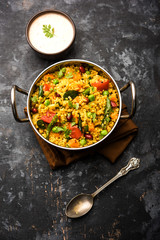 Broken wheat or Daliya Upma, served in a bowl. selective focus