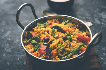 Broken wheat or Daliya Upma, served in a bowl. selective focus