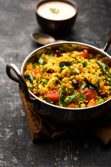 Broken wheat or Daliya Upma, served in a bowl. selective focus