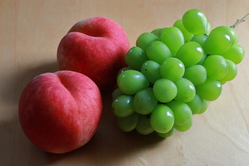 Fototapeta na wymiar Peaches and green grapes on the table